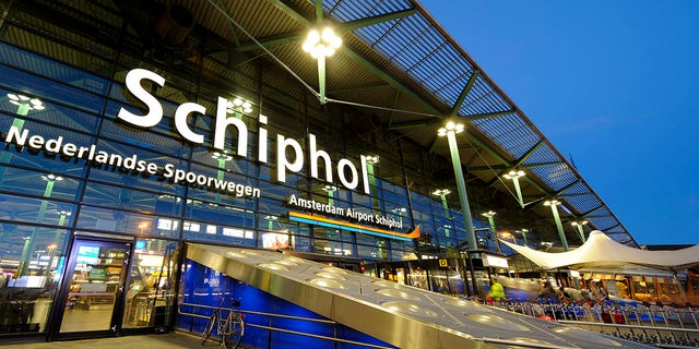 Illuminated entrance of Amsterdam Airport Schiphol at night.