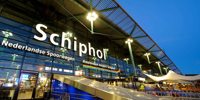 Illuminated entrance of Amsterdam Airport Schiphol at night.