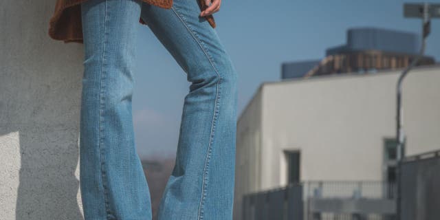 Detail photo of a girl wearing flared jeans.