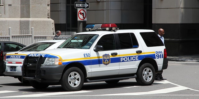 Philadelphia, United States June 11, 2013: Unidentified person walks by Philadelphia Police Ford Explorer. Philadelphia Police Department is the oldest city police agency in the US (formed 1751). 
