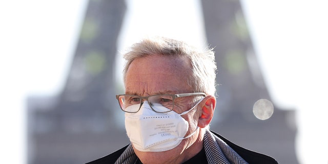 Um homem usando uma máscara facial caminha no Trocadero Place, perto da Torre Eiffel, em Paris, França, em 5 de janeiro de 2022. 