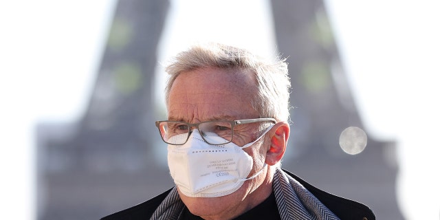 Um homem usando uma máscara facial caminha no Trocadero Place, perto da Torre Eiffel, em Paris, França, em 5 de janeiro de 2022.