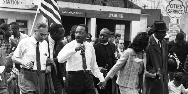 Mars 1965 : Martin Luther King (1929 - 1968) et son épouse Coretta Scott King mènent une marche pour les droits civiques de Selma, Alabama, à la capitale de l'État à Montgomery.  Sur la gauche (tenant une bouteille) se trouve le diplomate américain Ralph Bunche (1904 - 1971). 