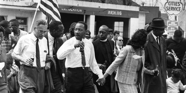 Mars 1965 : Martin Luther King (1929 - 1968) et son épouse Coretta Scott King mènent une marche pour les droits civiques de Selma, Alabama, à la capitale de l'État à Montgomery.  Sur la gauche (tenant une bouteille) se trouve le diplomate américain Ralph Bunche (1904 - 1971). 