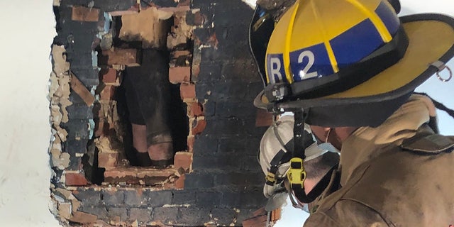 The suspected intruder was found stuck behind a wall in the chimney of the home.