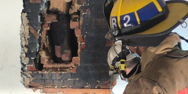 The suspected intruder was found stuck behind a wall in the chimney of the home.