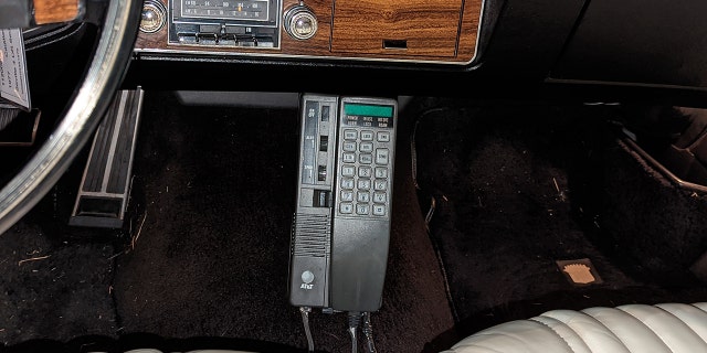White's Cadillac is equipped with an AT&T mobile phone.