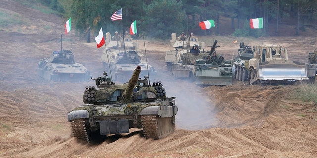 Military vehicles and tanks of Poland, Italy, Canada and United States roll during the NATO military exercises ''Namejs 2021'' at a training ground in Kadaga, Latvia, Sept. 13, 2021. 