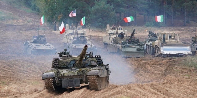 Military vehicles and tanks of Poland, Italy, Canada and United States roll during the NATO military exercises ''Namejs 2021'' at a training ground in Kadaga, Latvia, Sept. 13, 2021.