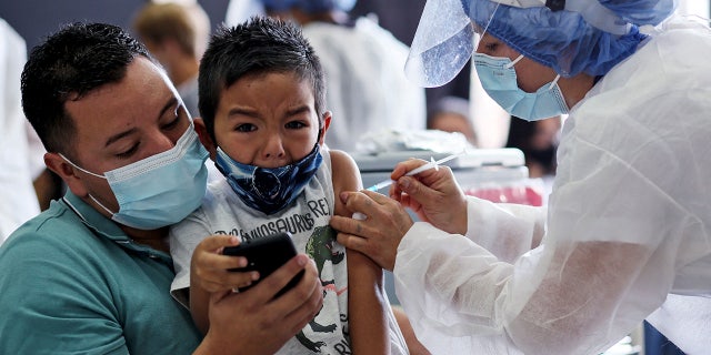 A health worker inoculates a boy with the CoronaVac vaccine, developed by China's Sinovac against the novel coronavirus disease COVID-19, at a vaccination centre in Bogota, en enero 4, 2022, as the World Health Organization (QUIÉN) warned that Omicron's dizzying spread increased the risk of newer, more dangerous variants emerging.