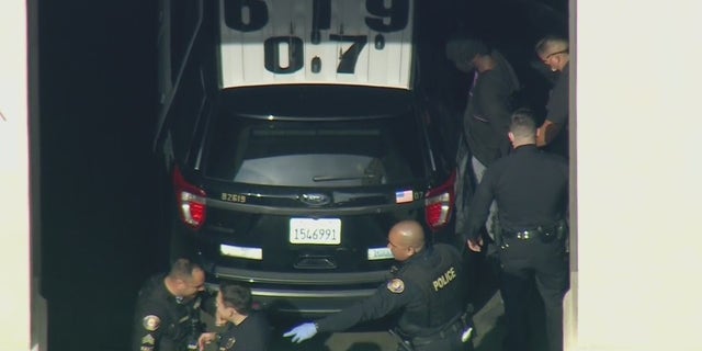 Aerial images obtained by FOX 11 Los Angeles show police placing him in the back of a police SUV prior to his expected transfer to LAPD custody.  