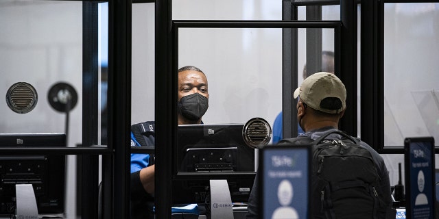 A Transportation Security Administration (TSA) agent screens a traveler at a checkpoint