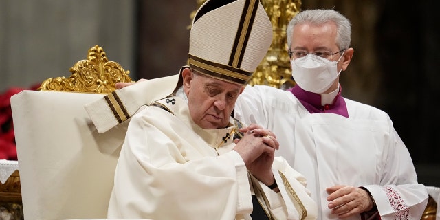 A master of ceremonies adjusts Pope Francis' mitre during an Epiphany mass in St. Peter's Basilica, at the Vatican, Thursday, Jan. 6, 2022.Â