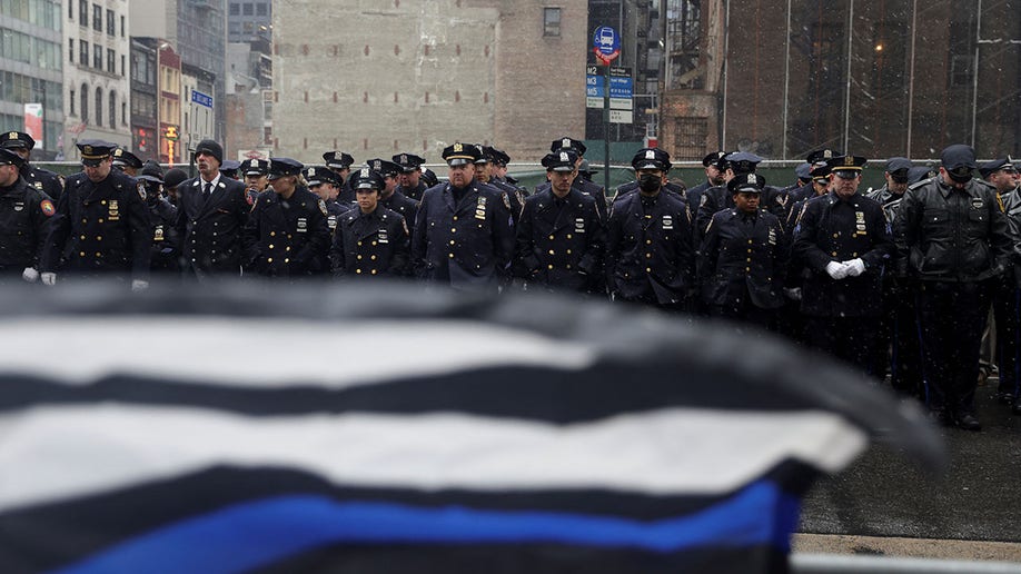 Police officers stand with a Blue Lives Matter flag in the foreground during the funeral service for New York City Police Department (NYPD) officer Jason Rivera, who was killed in the line of duty while responding to a domestic violence call, at St. Patrick's Cathedral in the Manhattan borough of New York City, Jan. 28, 2022.