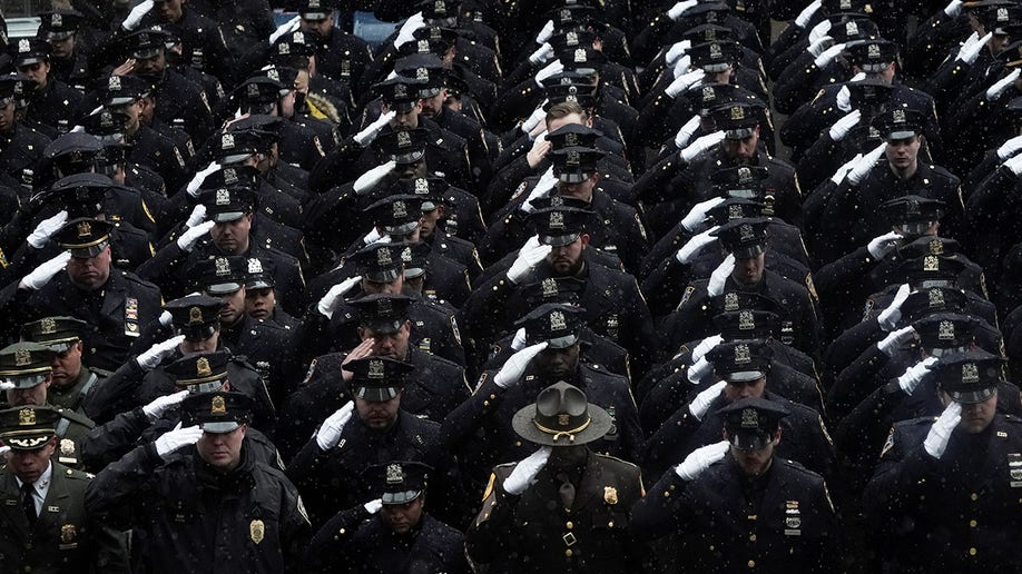 Law enforcement officers salute during the funeral service for New York City Police Department (NYPD) officer Jason Rivera, who was killed in the line of duty while responding to a domestic violence call, at St. Patrick's Cathedral in the Manhattan borough of New York City, Jan. 28, 2022. 