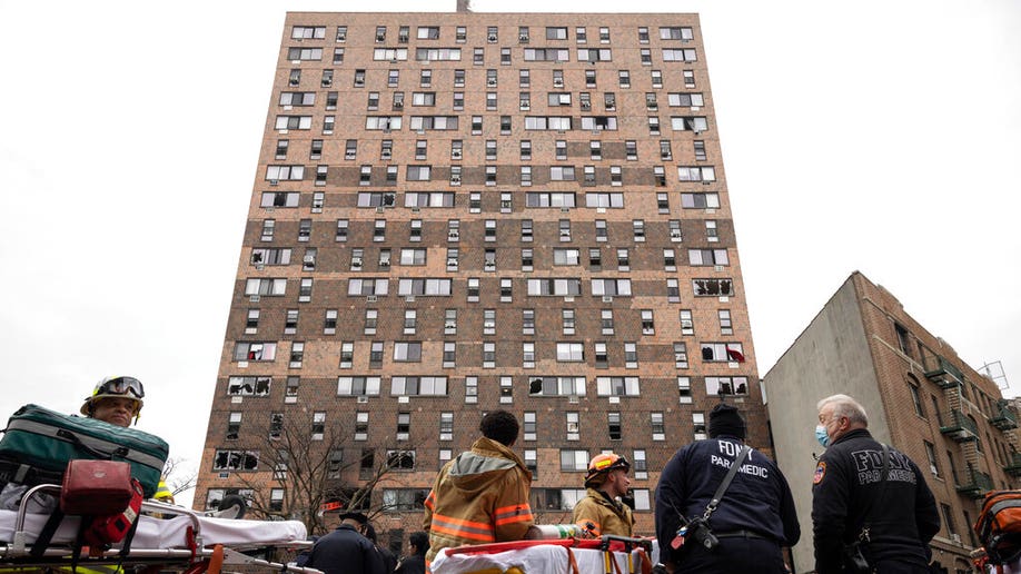 Emergency personnel work at the scene of a fatal fire at an apartment building in the Bronx