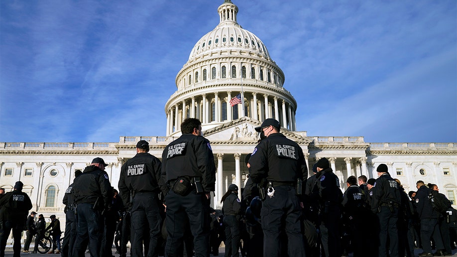 A large group of police arrive at the Capitol, Thursday, Jan. 6, 2022, in Washington.