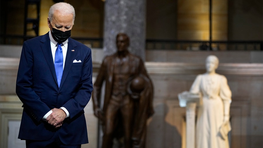 President Biden listens as Vice President Kamala Harris speaks from Statuary Hall at the U.S. Capitol to mark one year since the Jan. 6 riot at the Capitol by supporters loyal to then-President Trump, Thursday, Jan. 6, 2022, in Washington. 