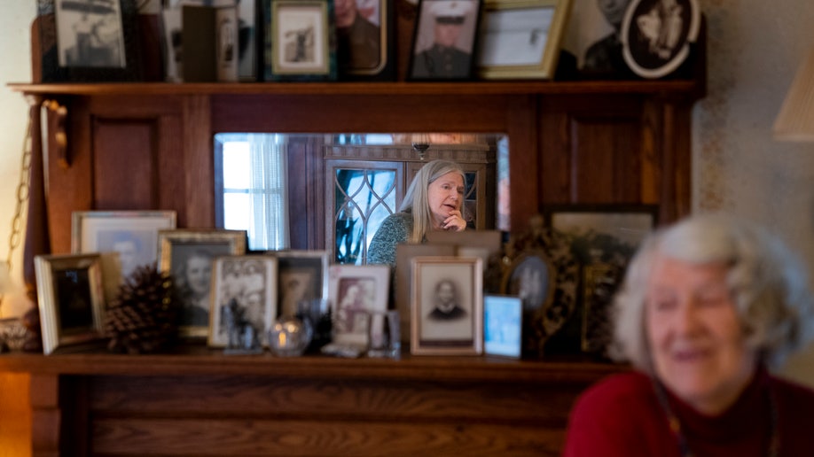 Nancy Rose, center in mirror, speaks with her mother, Amy Russell, right, who both contracted COVID-19 