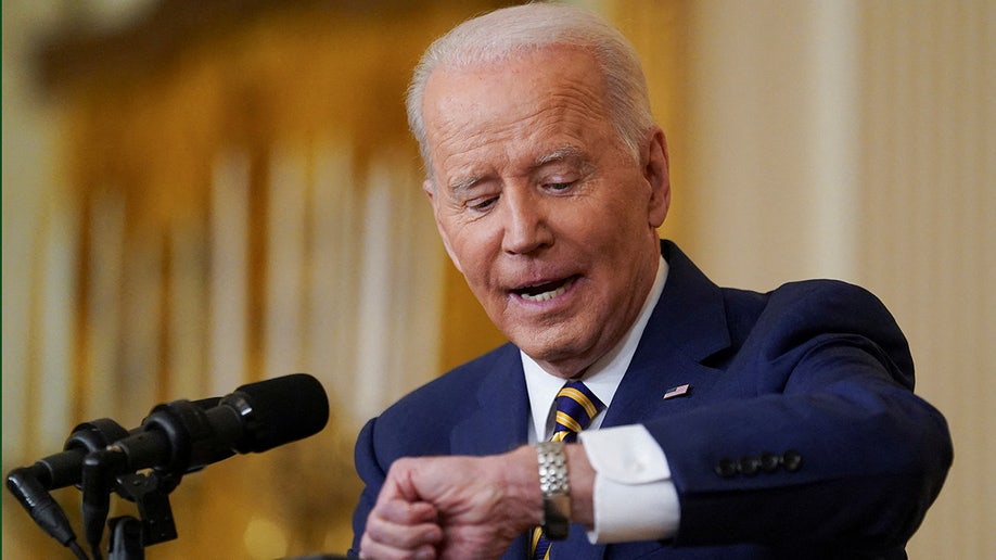 President Biden looks at his watch while holding a formal news conference Wednesday.