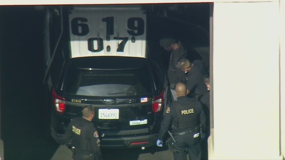 Aerial images obtained by FOX 11 Los Angeles show police putting him into the back of a police SUV ahead of his expected transfer to LAPD custody. 