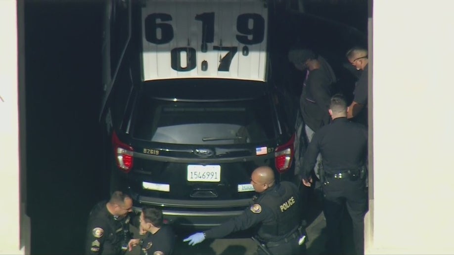 Aerial images obtained by FOX 11 Los Angeles show police putting him into the back of a police SUV ahead of his expected transfer to LAPD custody. 
