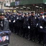 Calvin Hunt of Harlem holds a picture of NYPD officer Jason Rivera during his funeral service at St. Patrick's Cathedral in the Manhattan borough of New York City, on Jan. 28, 2022. (REUTERS/Jeenah Moon)