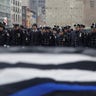 Police officers stand with "Blue Lives Matter" flag in the foreground during the funeral service for slain NYPD officer Jason Rivera, Jan. 28, 2022. (REUTERS/Jeenah Moon)