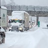 In this photo provided by the Oregon Department of Transportation, trucks are parked in the snow along Interstate 84 in the Columbia River Gorge about 60 miles east of Portland, Ore., Monday, Jan. 3, 2022. Heavy snow and high winds forced officials to close dozens of state roads in eastern Oregon on Monday and Interstate 84 was shut down through the Columbia River Gorge, while blowing snow also closed a major road over the Cascade Mountains in Washington. 