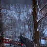 A commuter bus sits upright on a section of a collapsed bridge in Pittsburgh, on Friday, Jan. 28, 2022.  (Greg Barnhisel via AP)