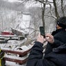 Allegheny County Executive Rich Fitgerald, right, takes a photo of the scenes where a bridge collapsed, Friday Jan. 28, 2022, in Pittsburgh's East End.  (AP Photo/Gene J. Puskar)