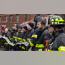 Firefighters work at the scene of a fatal fire at an apartment building in the Bronx