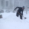 People shovel in the heavy snow and wind in Cohasset, MA on Jan. 29, 2022.