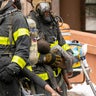 A firefighter carries a child after the Bronx apartment fire