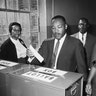 Dr. Martin Luther King Jr. votes as his wife, Coretta Scott King, waits her turn on Nov. 3, 1964 in Atlanta.