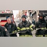 Firefighters work outside an apartment building after a fire in the Bronx