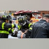 A victim of the Bronx apartment fire is helped by firefighters