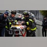 A victim of the Bronx apartment fire is helped by firefighters