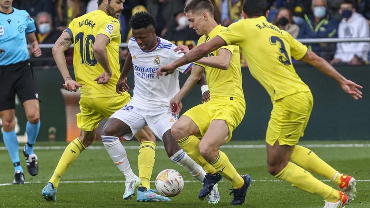 Real Madrid's Vinicius Junior, second left, duels for the ball with Villarreal's Vicente Iborra during a Spanish La Liga soccer match between Villarreal and Real Madrid at the Ceramica stadium in Villarreal, Spain, Saturday, Feb. 12, 2022.