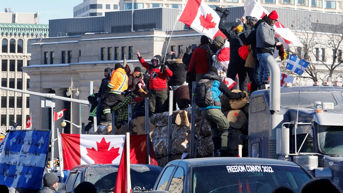 Protesters stand on a trailer carrying logs as truckers and supporters take part in a convoy to protest coronavirus disease (COVID-19) vaccine mandates for cross-border truck drivers in Ottawa, Ontario, Canada, Jan. 29, 2022. 