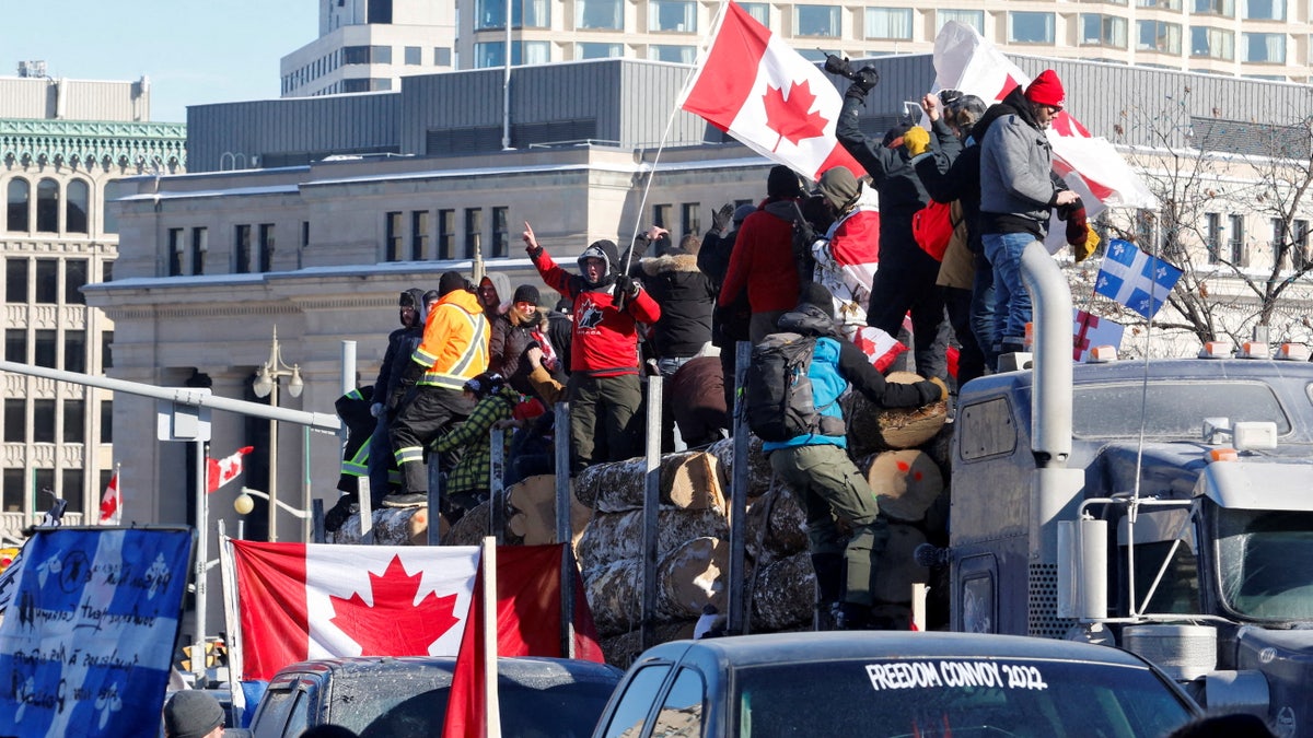 FILE PHOTO: Protestors stand on a trailer carrying logs as truckers and supporters take part in a convoy to protest coronavirus disease (COVID-19) vaccine mandates for cross-border truck drivers in Ottawa, Ontario, Canada, January 29, 2022. REUTERS/Patrick Doyle/File Photo