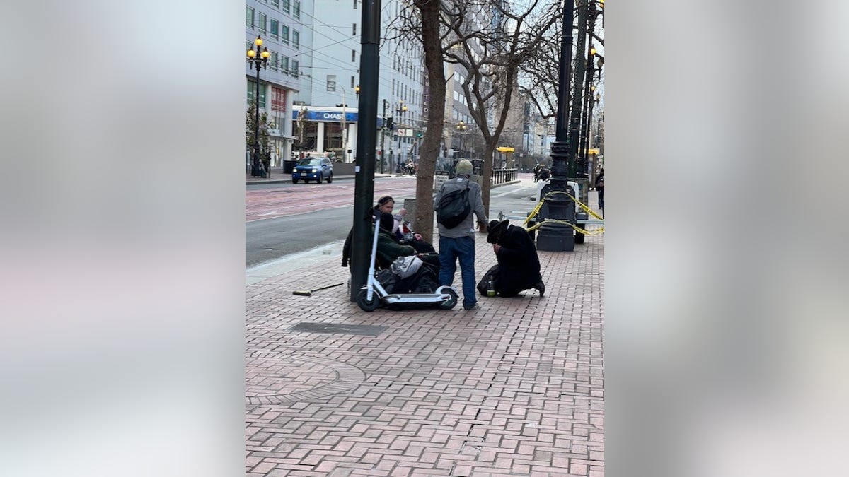 Homeless people sit in San Francisco’s Tenderloin District 