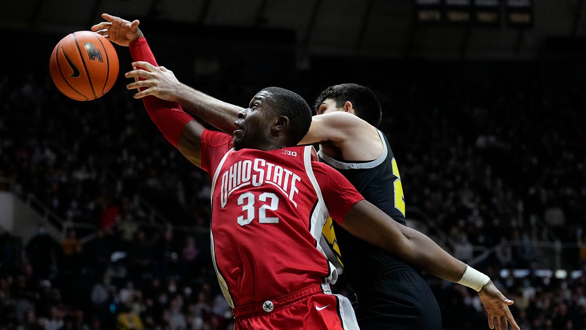 Ohio State forward E.J. Liddell, left, fights for a rebound with Purdue guard Ethan Morton (25) in the first half of an NCAA college basketball game in West Lafayette, Ind., Sunday, Jan. 30, 2022.