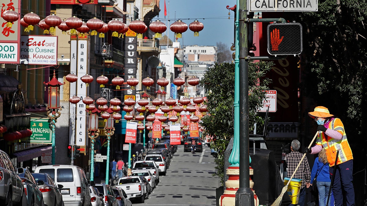 A worker cleans a street Friday, Jan. 31, 2020, in the Chinatown district in San Francisco. 