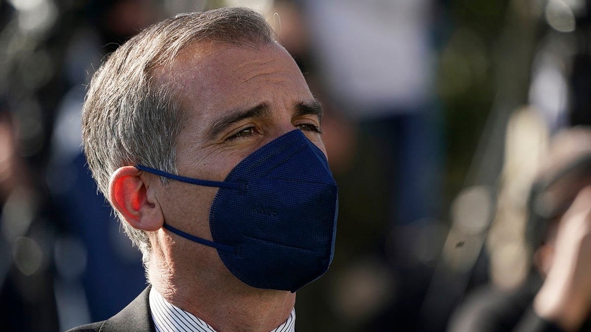 Los Angeles Mayor Eric Garcetti wears a mask as he listens to fellow speakers at a news conference near SoFi Stadium, site of the NFL football Super Bowl later this month, Wednesday, Feb. 2, 2022, in Inglewood, Calif.