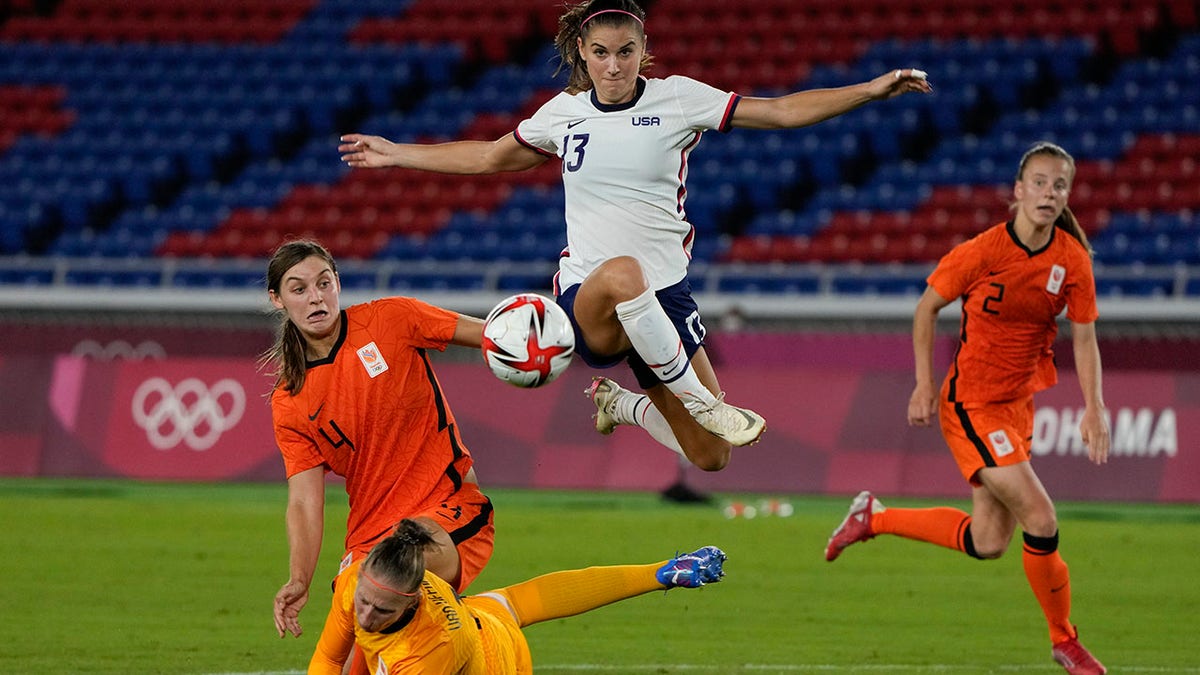 FILE - United States' Alex Morgan jumps over Netherlands' goalkeeper Sari van Veenendaal as she attempts to score during a women's quarterfinal soccer match at the 2020 Summer Olympics, Friday, July 30, 2021, in Yokohama, Japan. The U.S. Equal Employment Opportunity Commission has asked for permission to participate in the appeal by American women soccer players trying to reinstate their pay claim against the U.S. Soccer Federation. The EEOC asked the 9th U.S. Circuit Court of Appeals on Thursday, Feb. 3, 2022, to be allowed to address the court during oral arguments scheduled for March 7 in Pasadena, California.
