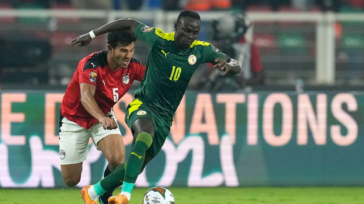Senegal's Sadio Mane, right, controls the ball away from Egypt's Hamdi Fathi during the African Cup of Nations 2022 final soccer match between Senegal and Egypt at the Ahmadou Ahidjo stadium in Yaounde, Cameroon, Sunday, Feb. 6, 2022.