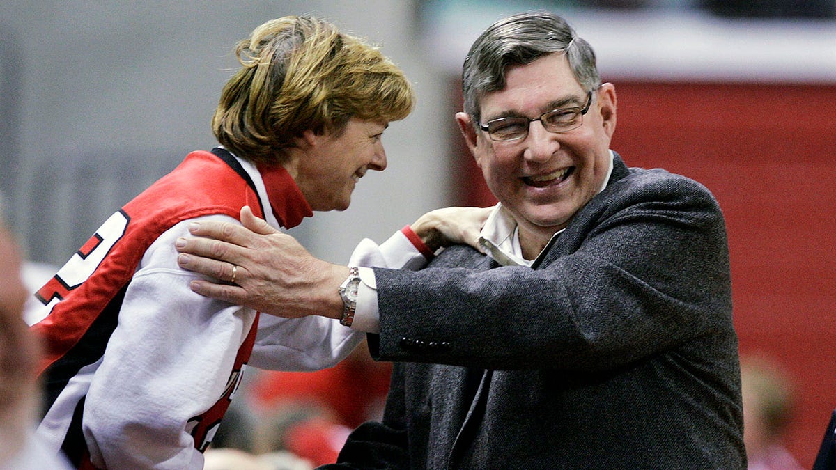 FILE - Rutgers athletic director Robert E. Mulcahy III, right, is greeted by a supporter Thursday, Dec. 11, 2008, in Piscataway, N.J., before a women's basketball game.  Mulcahy, who served as athletics director for the state’s flagship university and held many high-ranking government posts during his decades of service, has died. Mulcahy’s family announced his death Tuesday, Feb. 8, 2022, saying he had passed away Monday after a long illness.