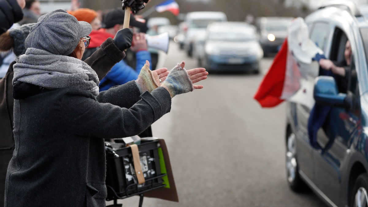 People applaud a convoy departing for Paris, Friday, Feb.11, 2022 in Strasbourg, eastern France.