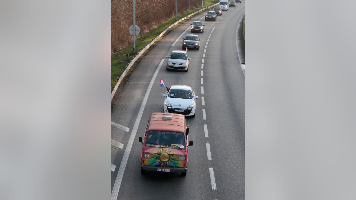 Cars part of a blockade drive on a motorway Friday, Feb.11, 2022 in Lille, northern France.